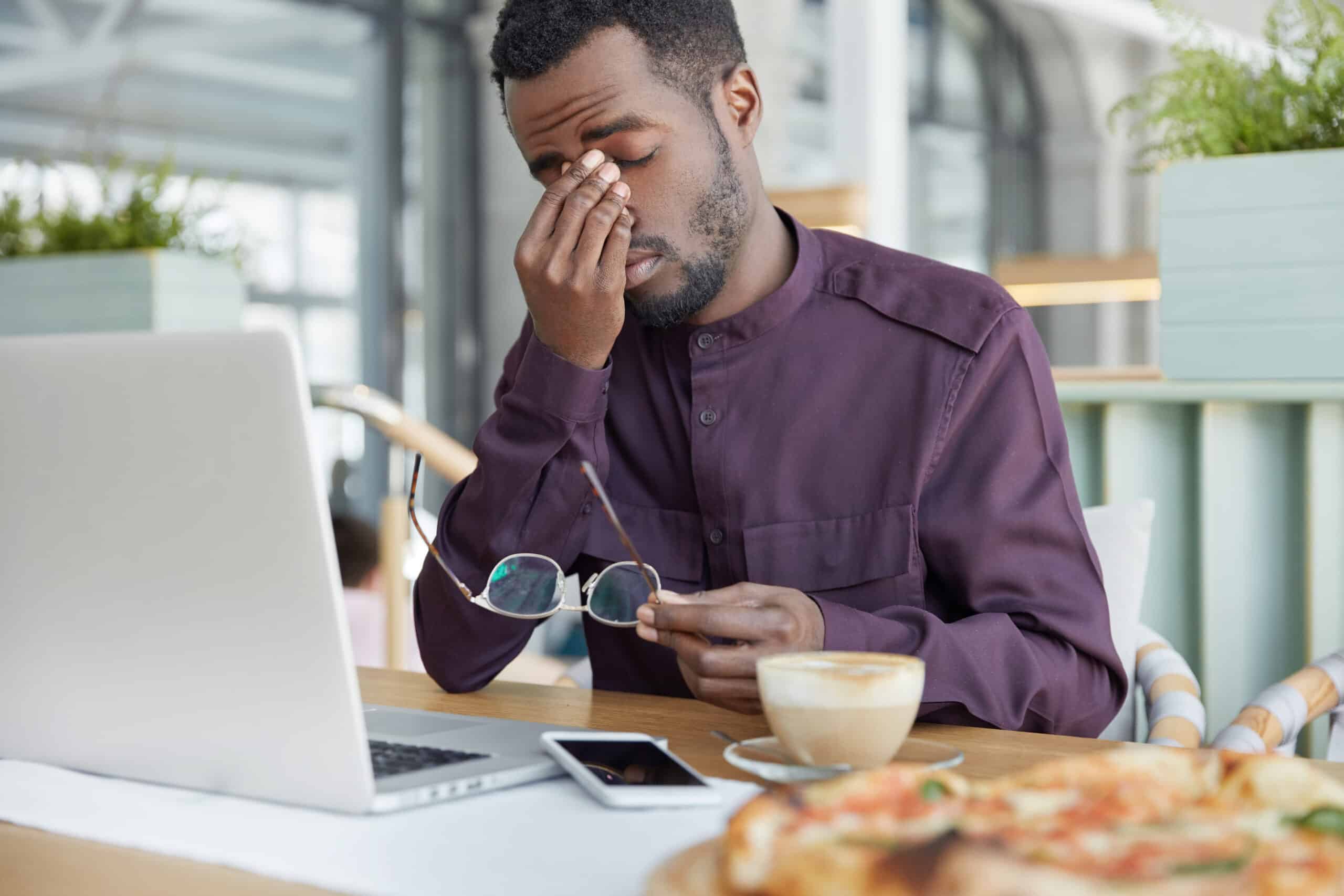 man suffering from work stress sitting in front of a laptop in need of depression treatment in washington dc